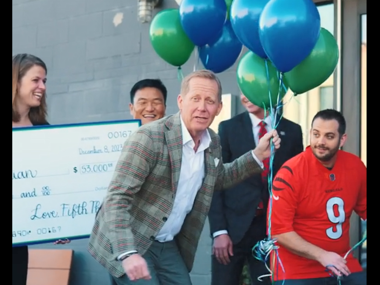 Group with a large check, balloons, getting ready to go inside the RODI restaurant