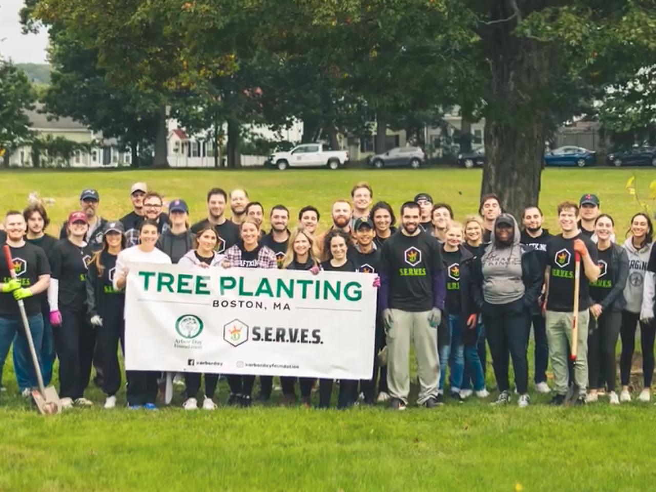 Boston DraftKings employees holding Tree Planting sign
