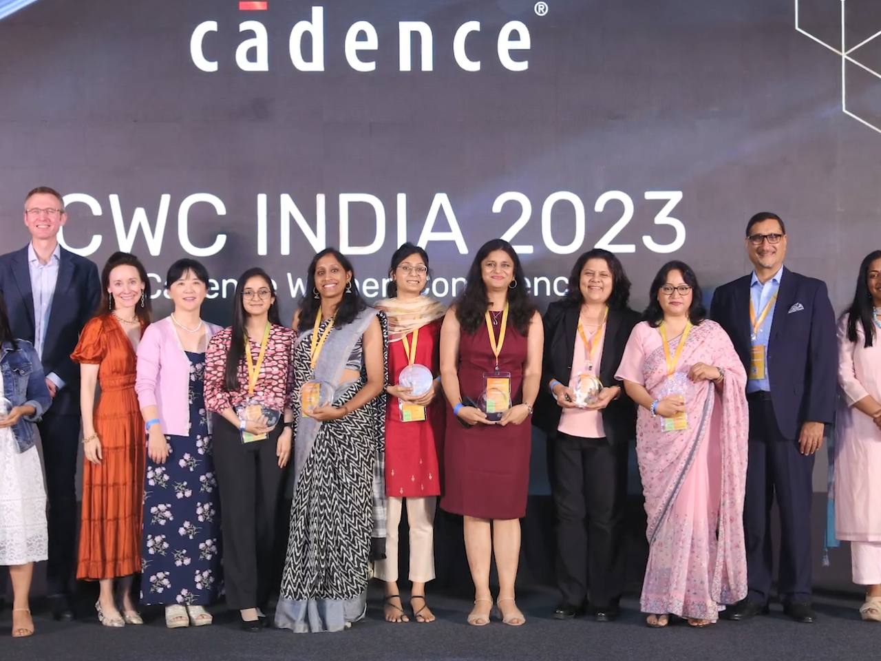 A group of people on a stage, many holding awards "CWC India 2023" behind them.