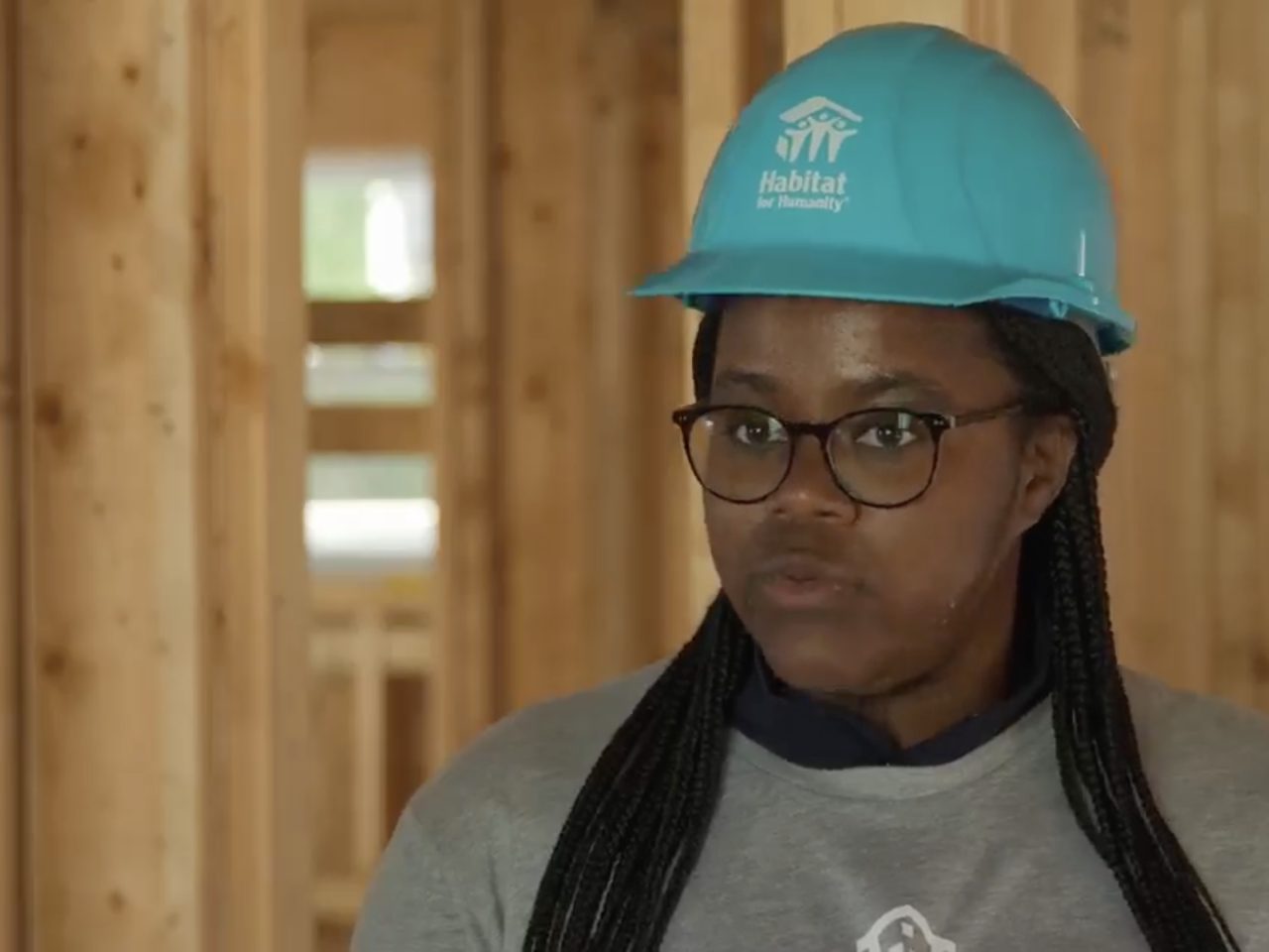 Ryan Estmond wearing a safety hat inside of a building under construction  