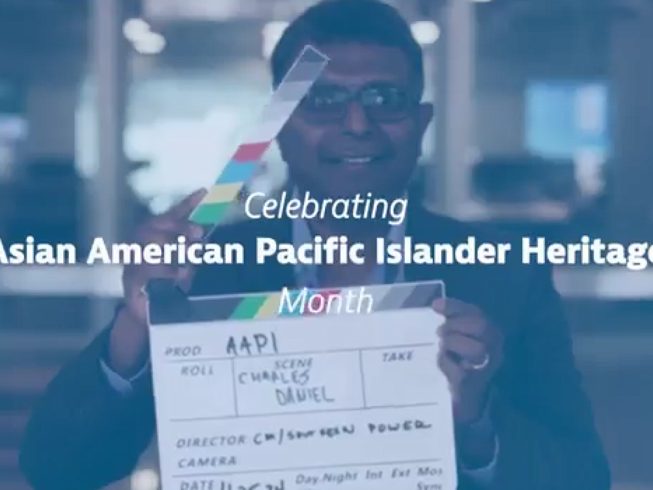 A person holding a clapboard. "Celebrating Asia American Pacific Islander Heritage" super imposed on top.