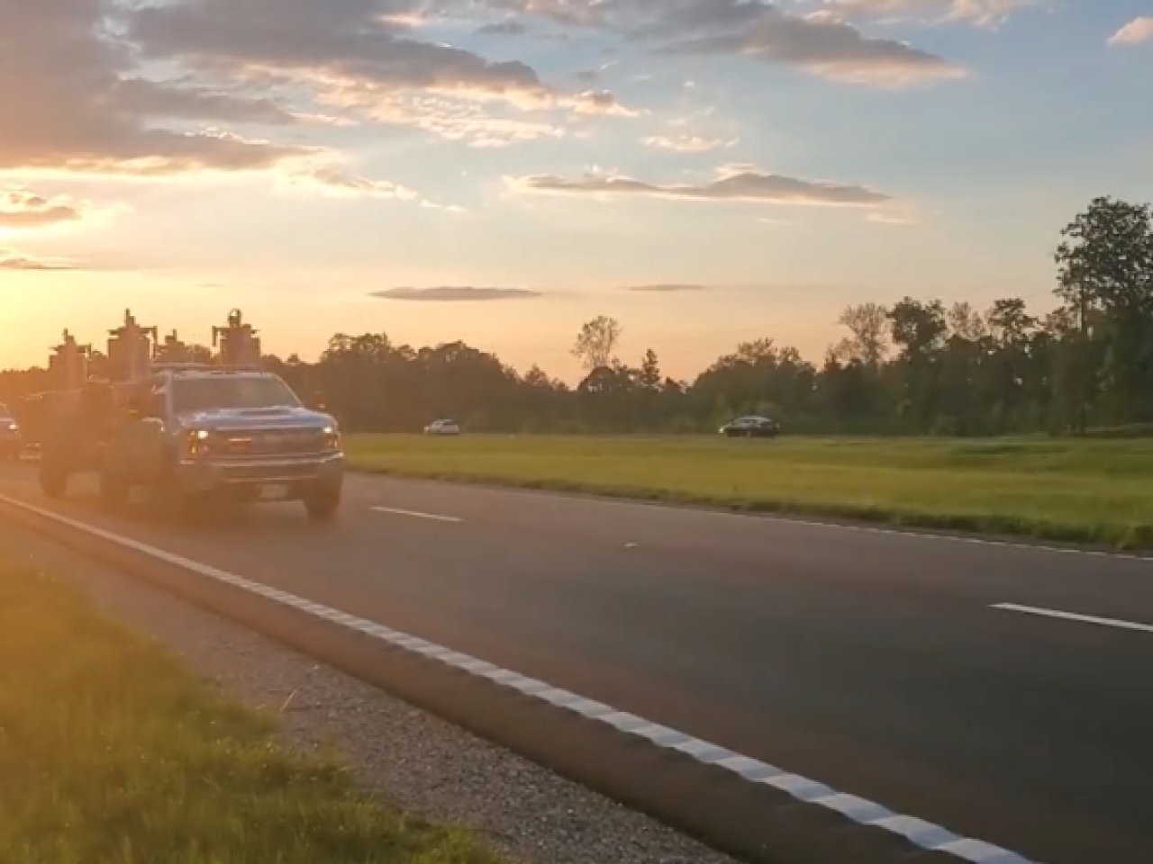Truck on the highway with a sunset behind it