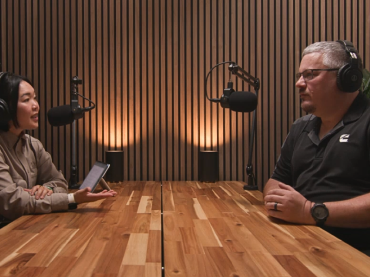 Two people speaking into microphones