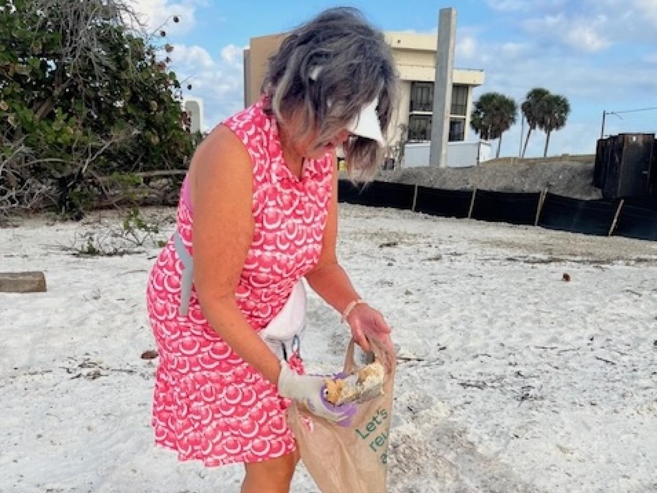 Chris picking up trash on the beach.