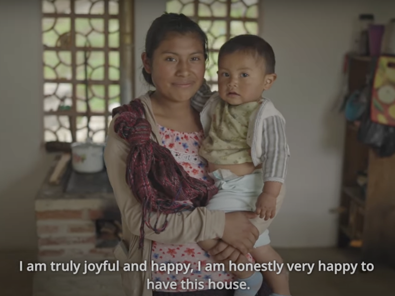 A mother holding her child in their new family home.