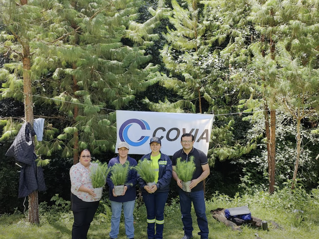 people holding plants in front of trees