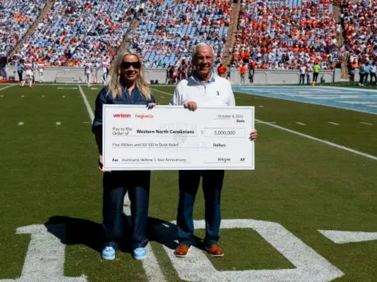 Two people holding an oversized check