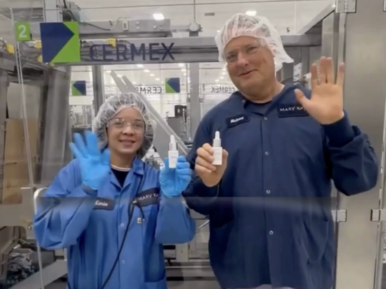 two people smiling and waving