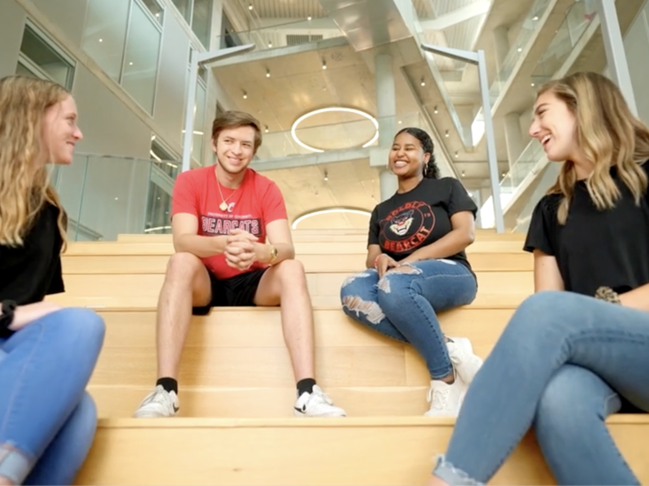 Four college students sitting on stairs