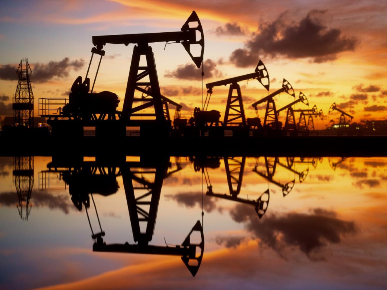 Oil wells with a sunset in the background