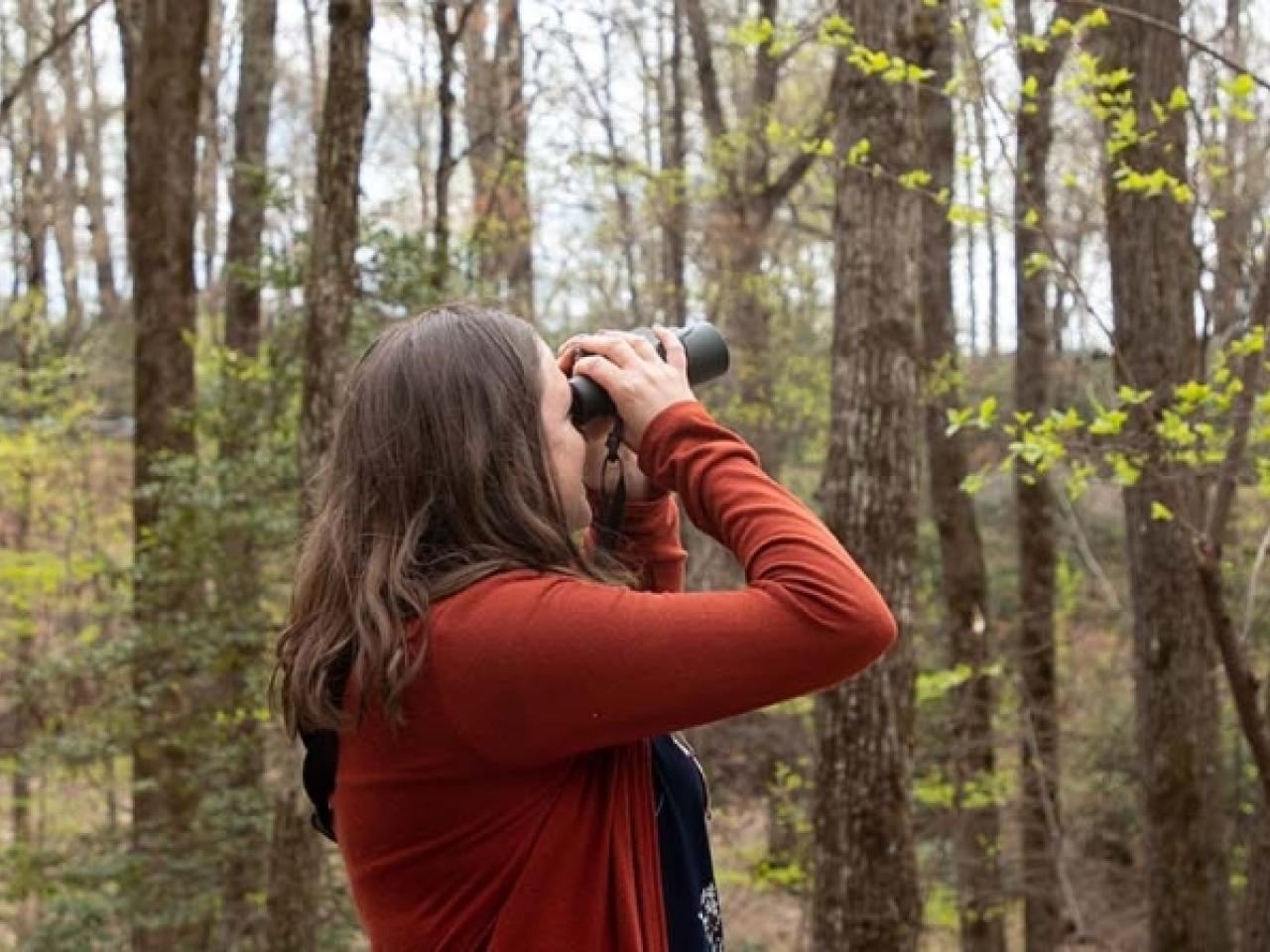 Audubon South Carolina’s Jennifer McCarthey Tyrrell, in orange sweater, looking through binoculars