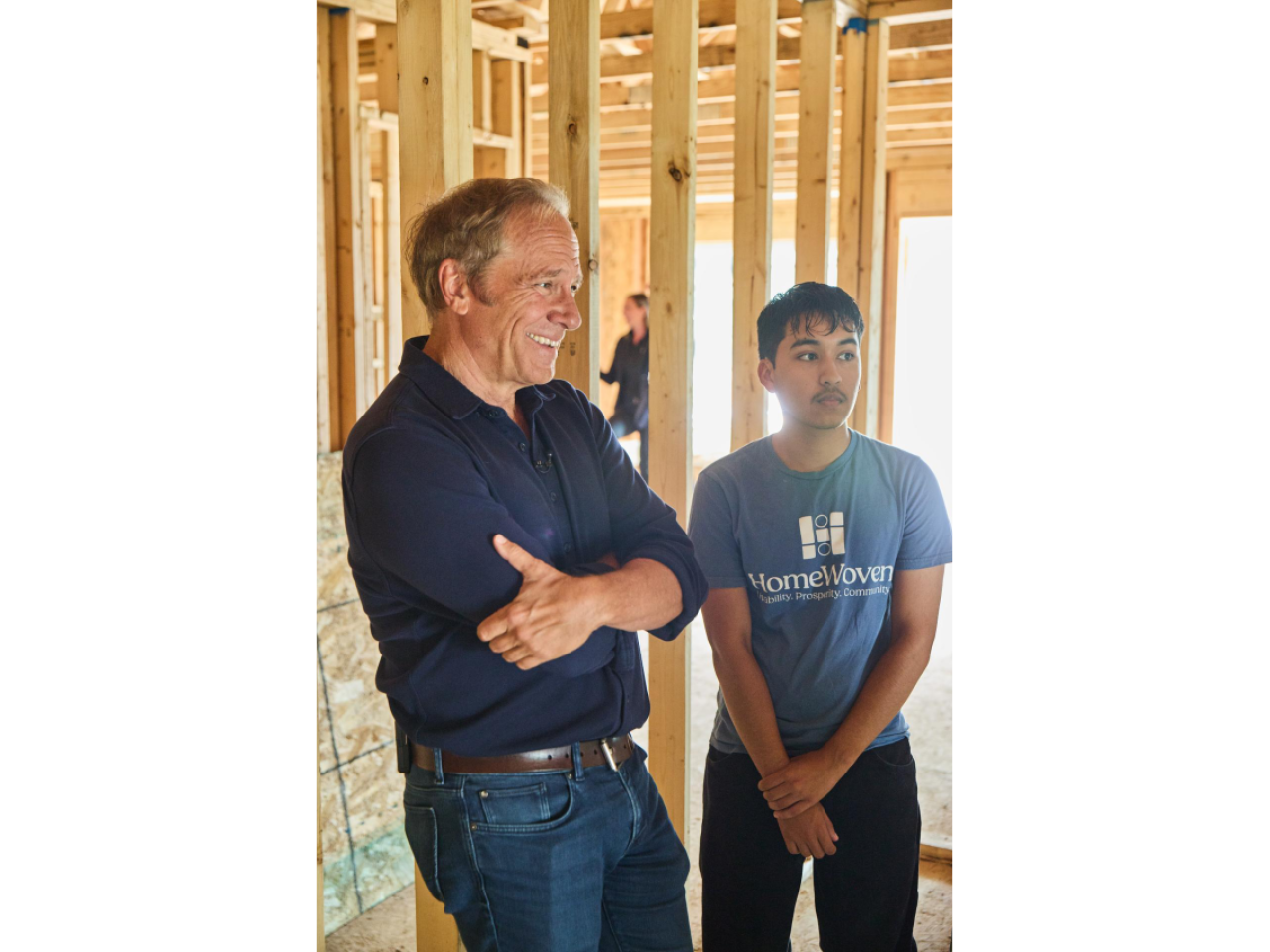 Two people stand inside a home under construction