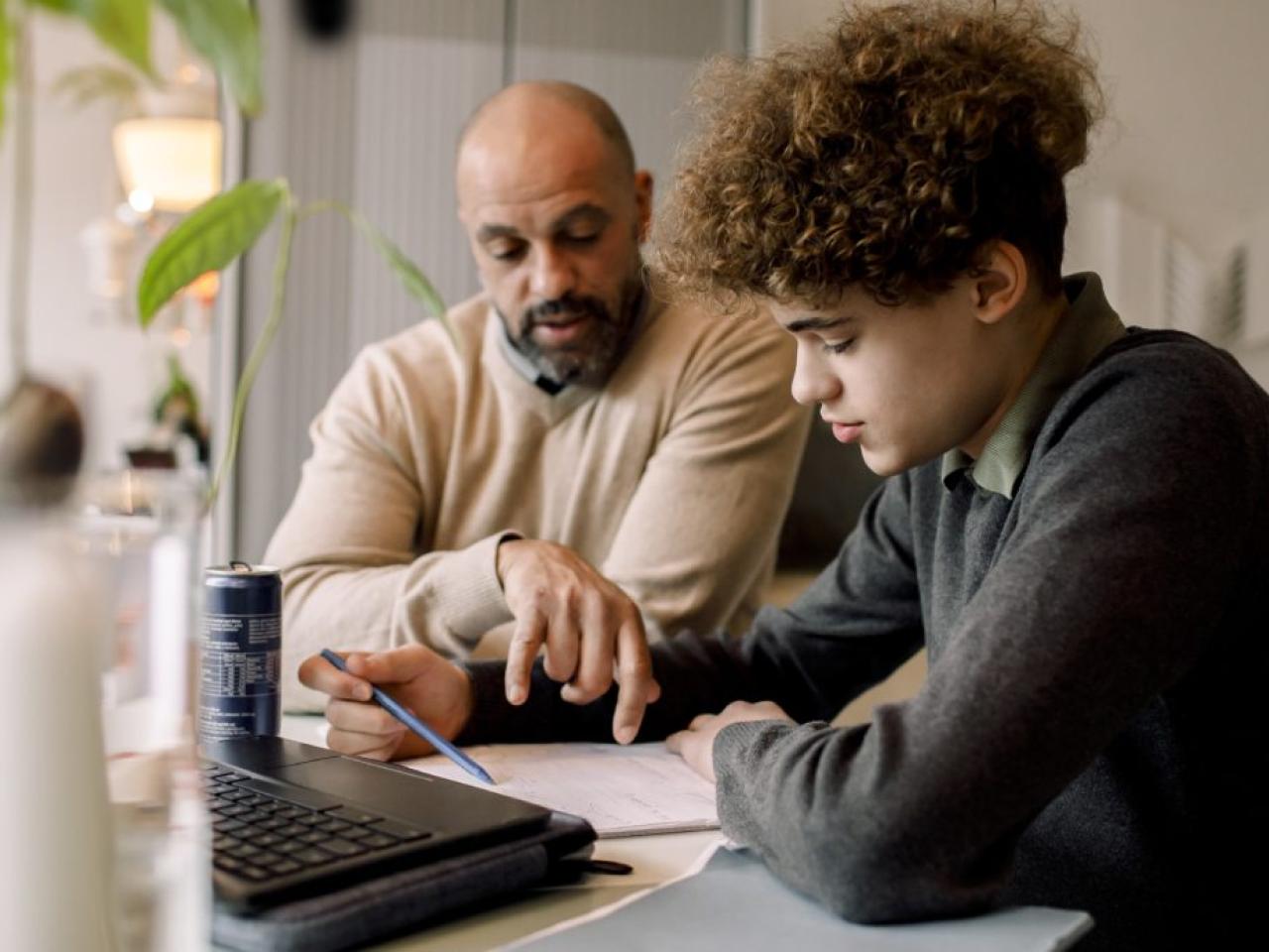 Parent and teenager looking at homework together