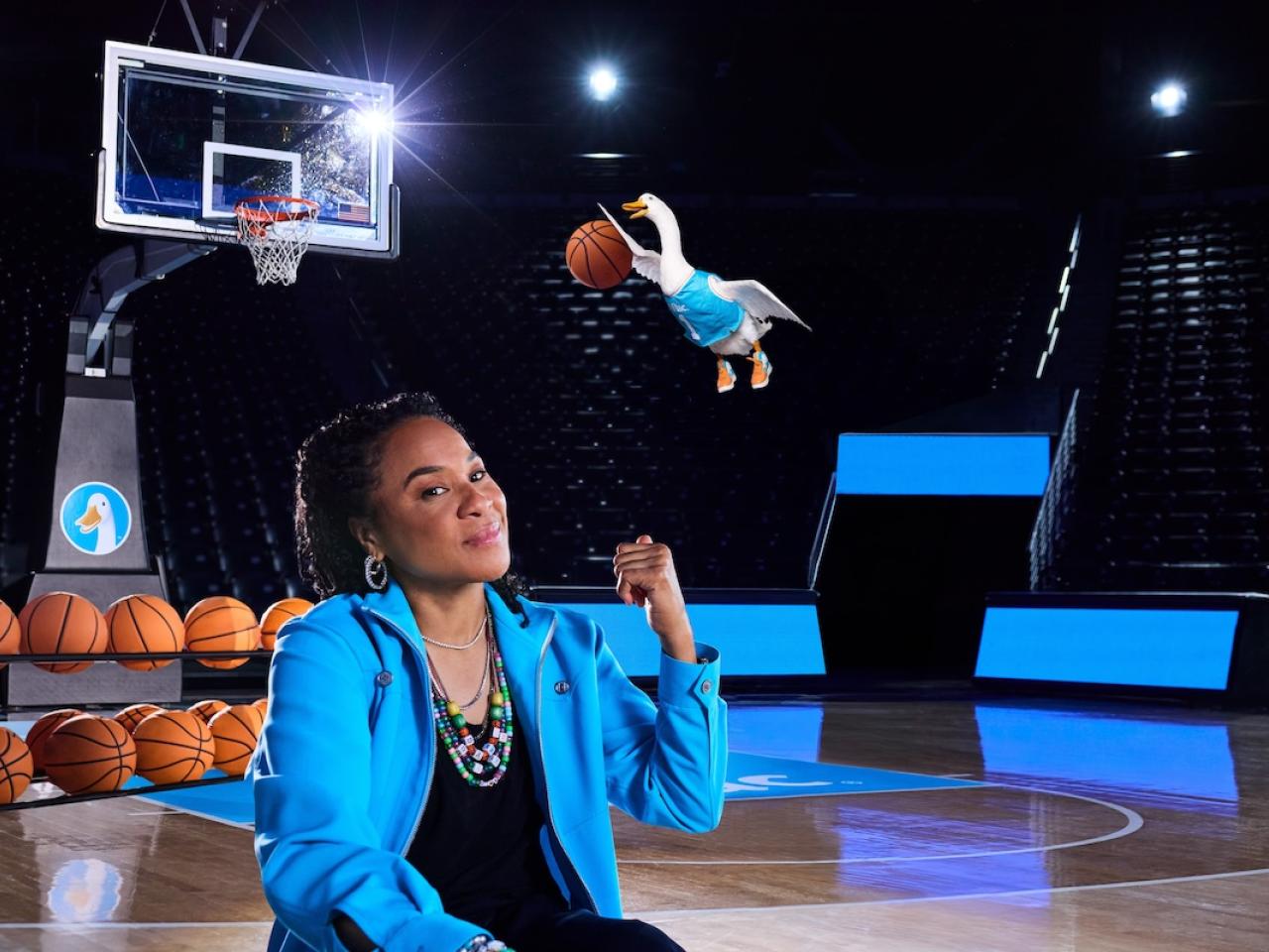 Dawn Staley and the Aflac Duck shown slam dunking a basketball.
