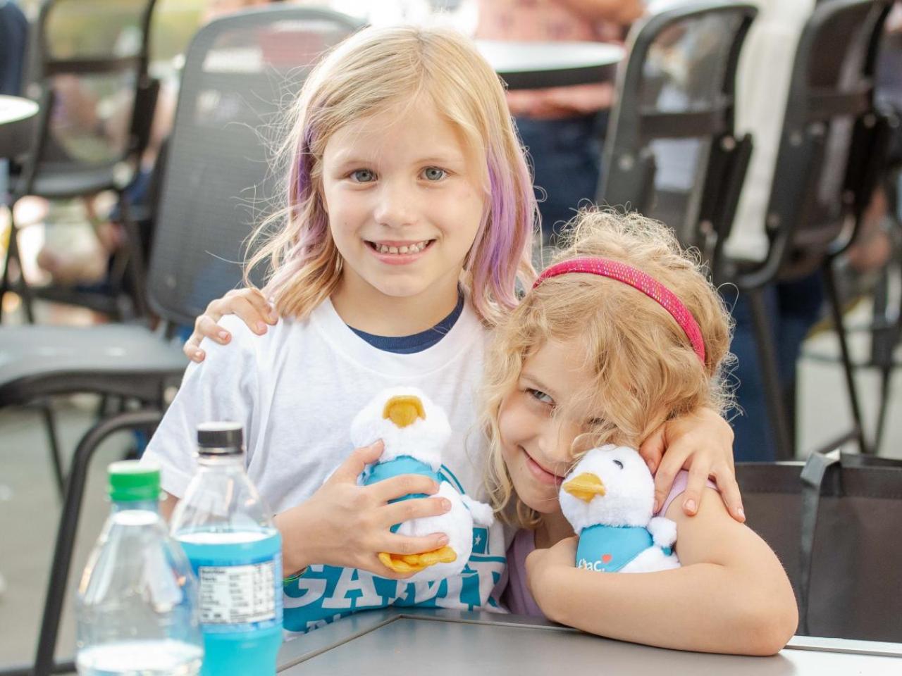 Two children at the Night of Baseball holding Aflac Ducks.