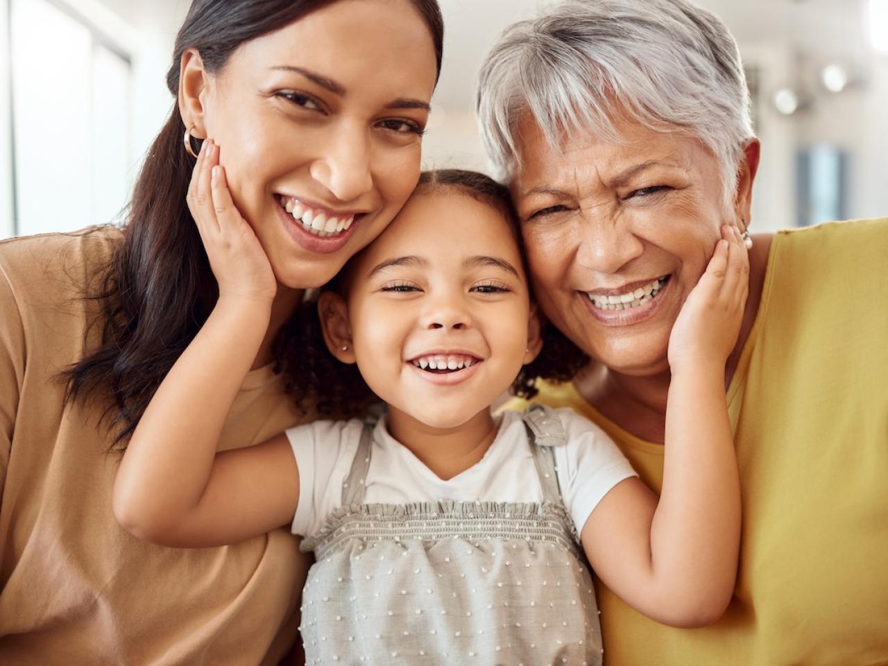 A mom, daughter and grandmother shown in a hug.