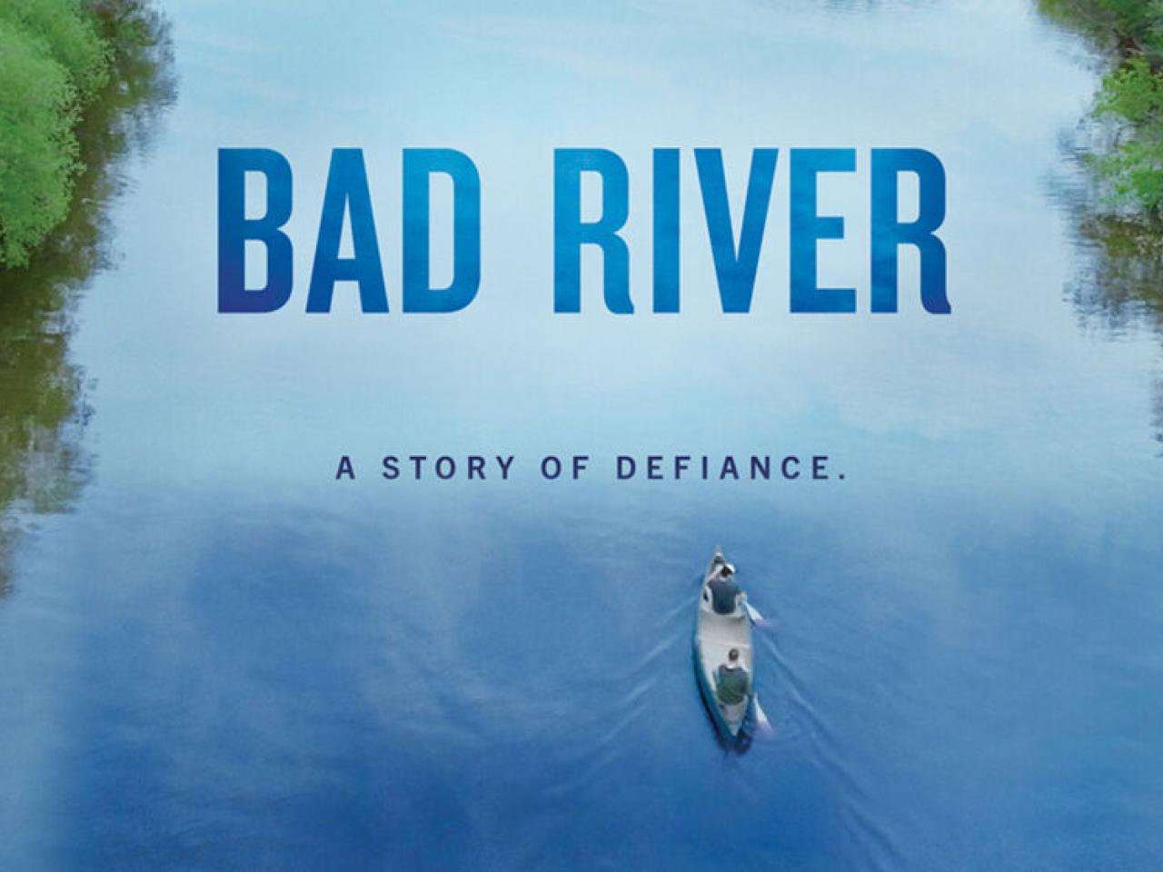 Two people in a canoe on a tree-lined river. "Bad River. A story of defiance."