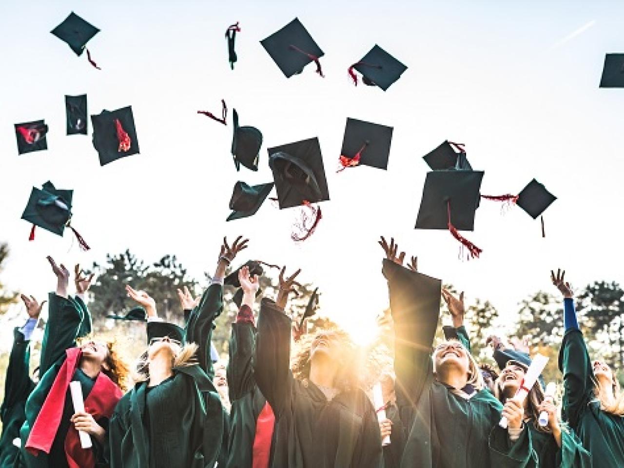 Group of graduates throwing their hat in the air