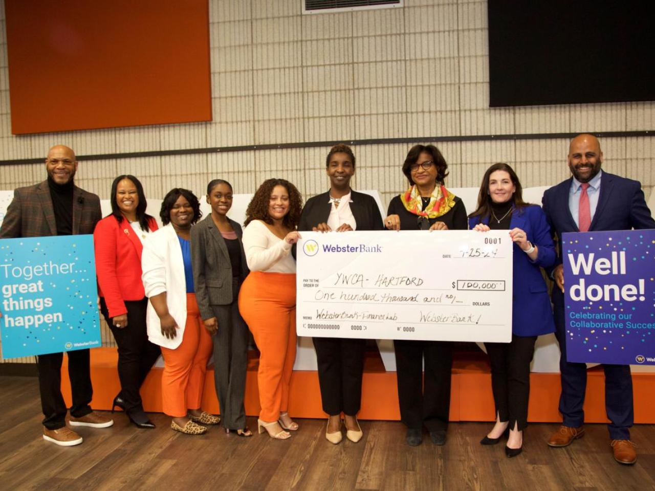 group standing with an oversized check