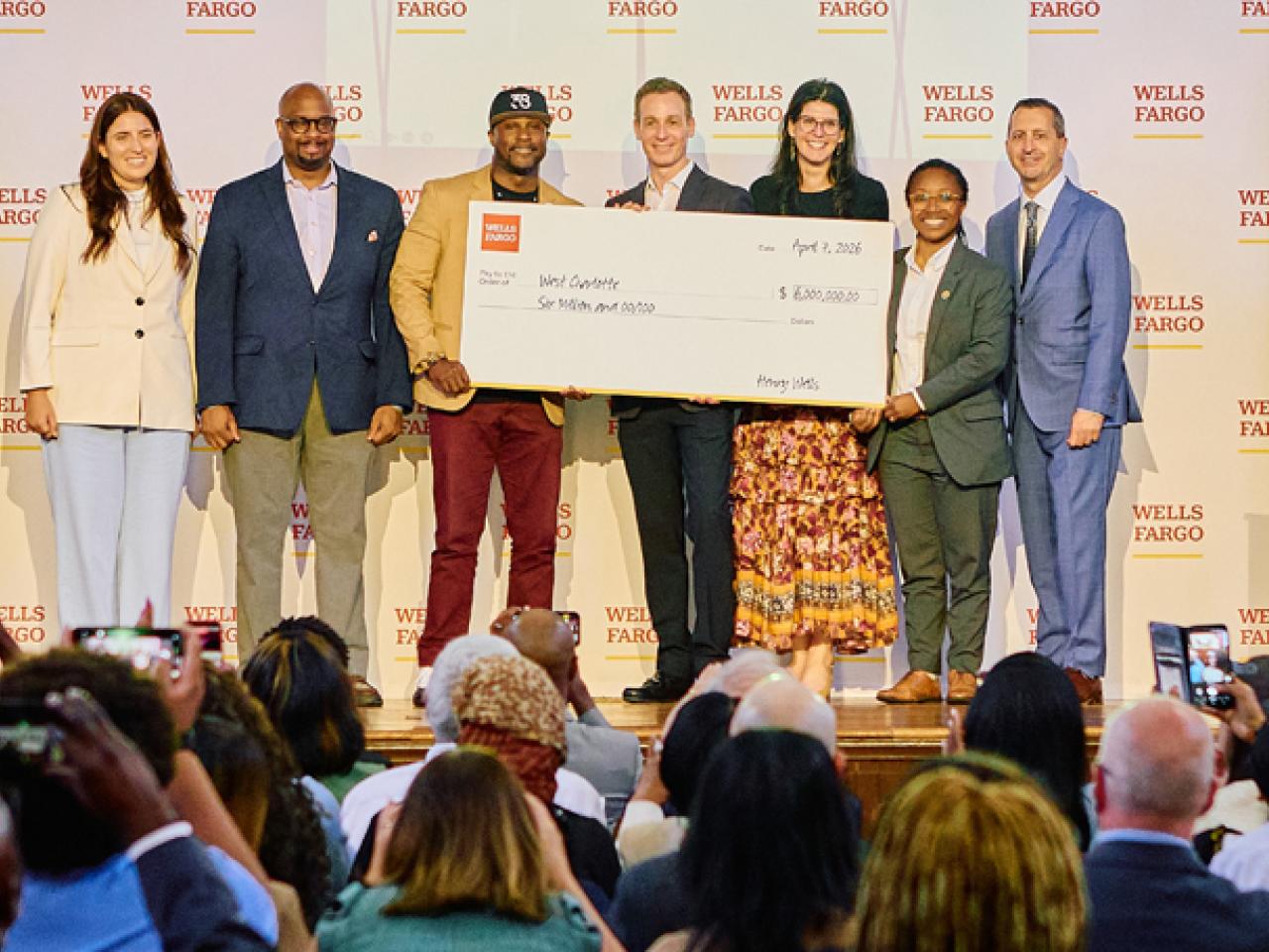 People on stage with big check