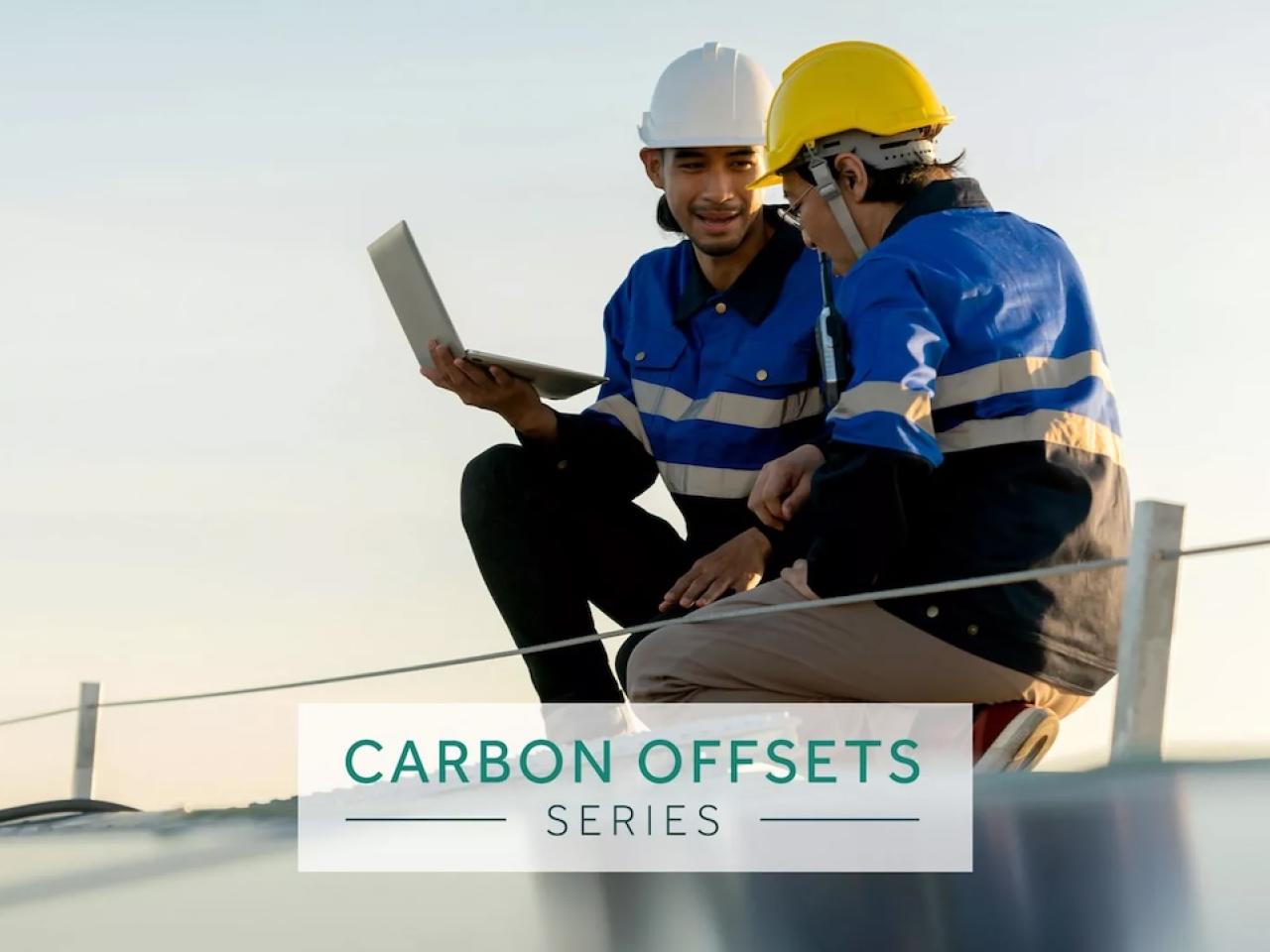 Carbon Offsets Series: Two technicians working on a solar panel.
