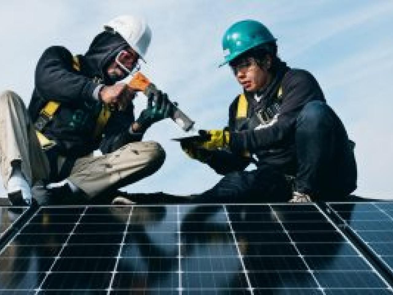2 people installing a solar panel
