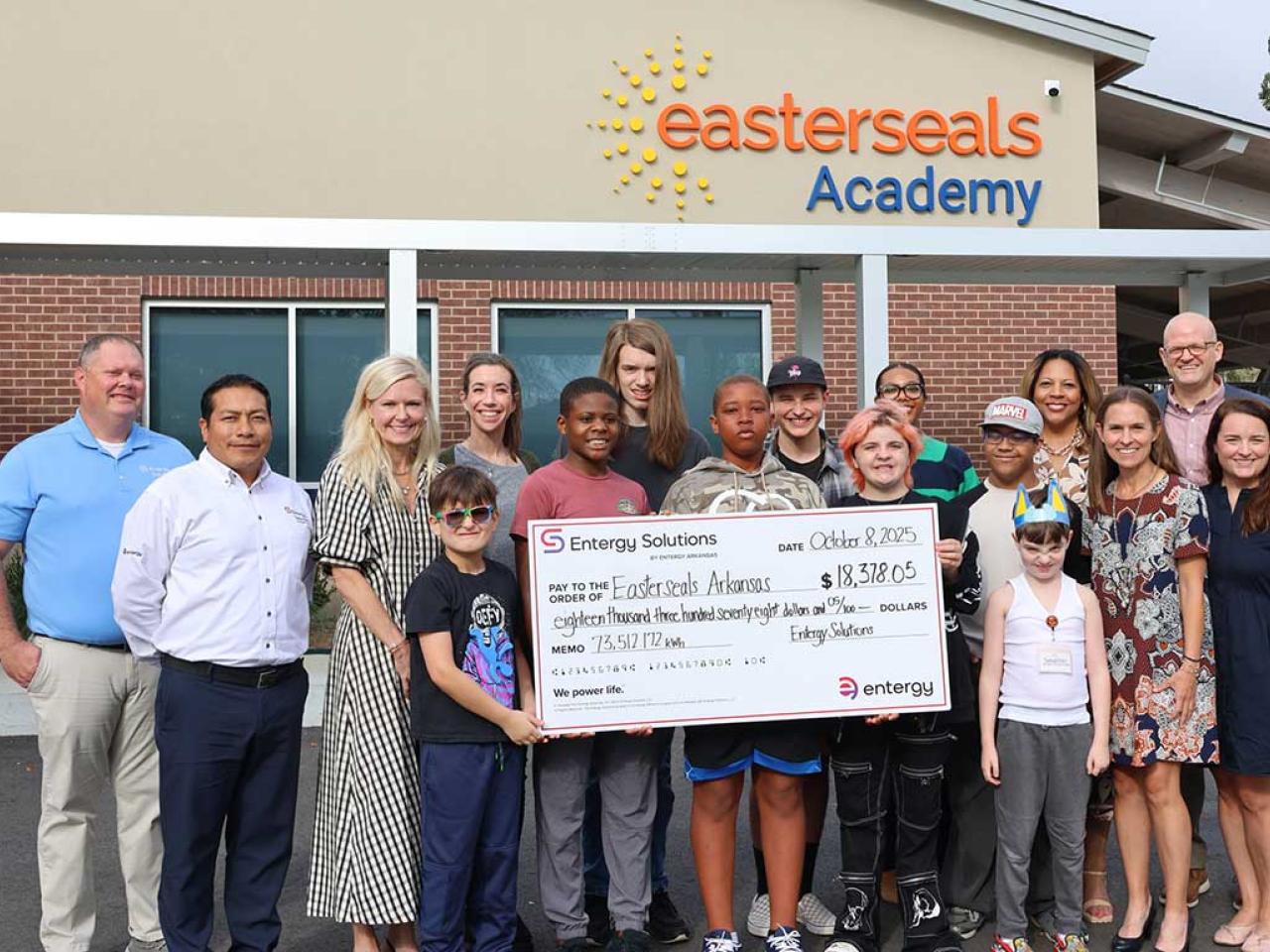 people holding up large poster of check