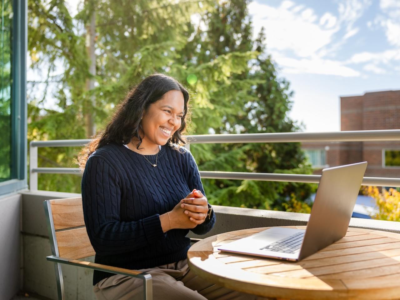 GoDaddy employee sitting outside with a laptop.