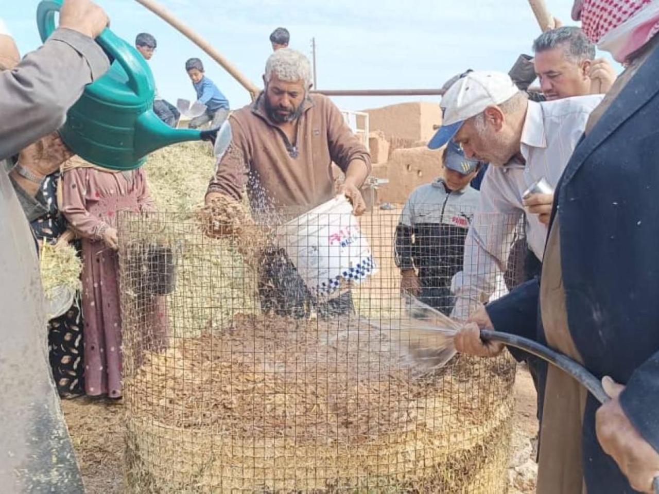 Ibrahim (center) and other farmers learn to make compost.