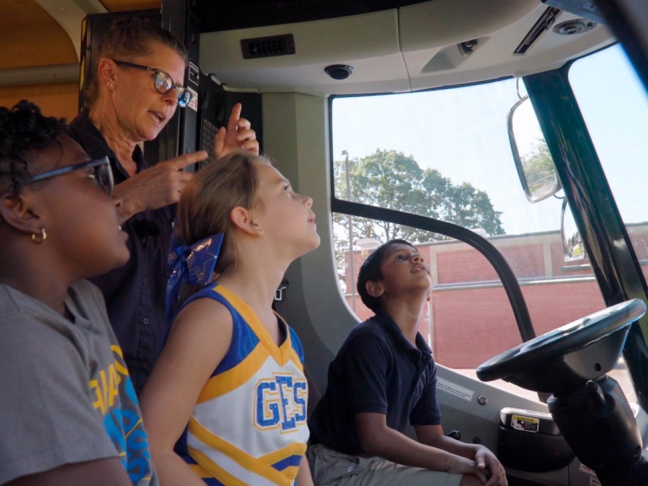 4 people sitting in the front seats of a van