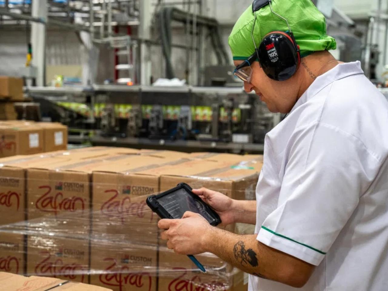 Person working in warehouse looking at tablet