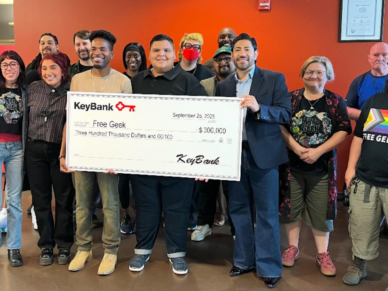 Representatives from Free Geek and KeyBank shown with a grant check for $300,000.