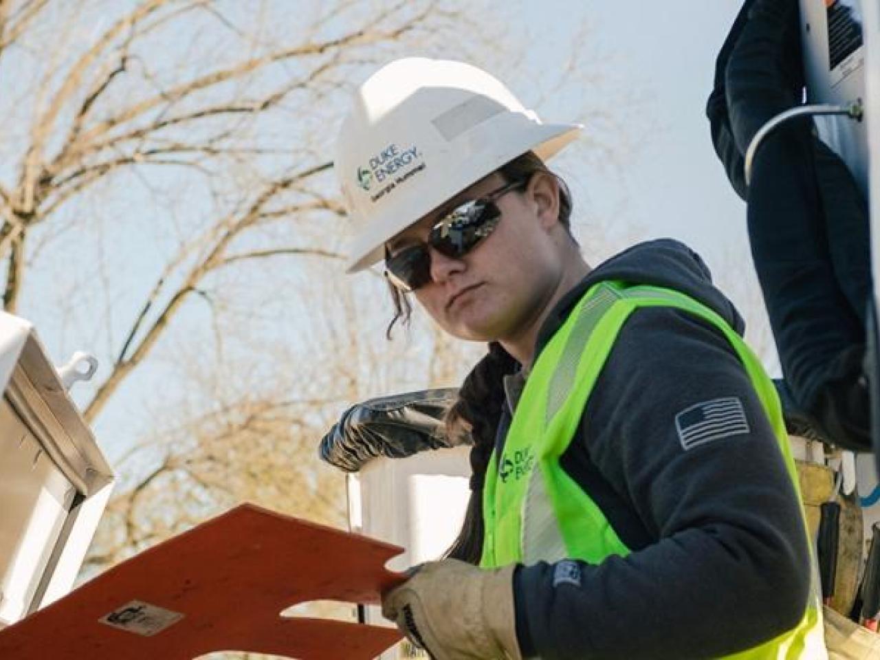 Georgia Hummel in safety wear, looking at a panel outside.