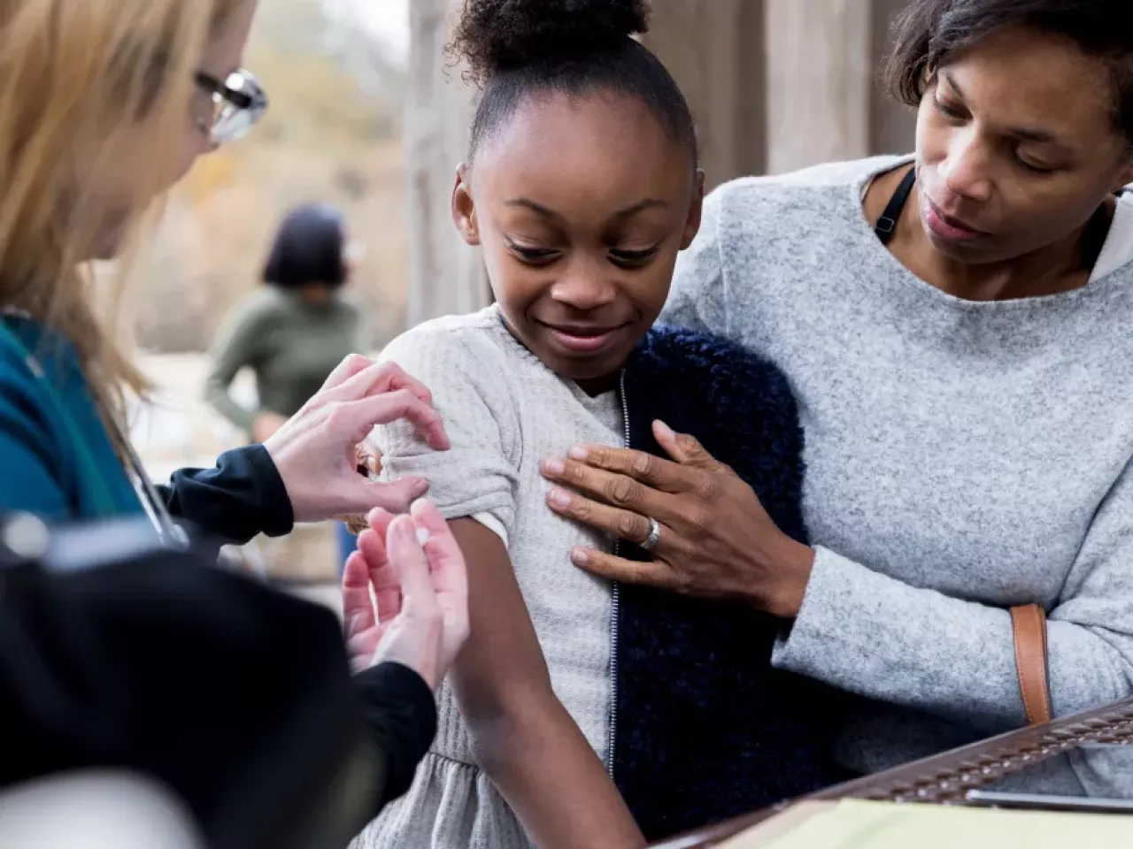 A girl receiving a vaccination by a doctor 