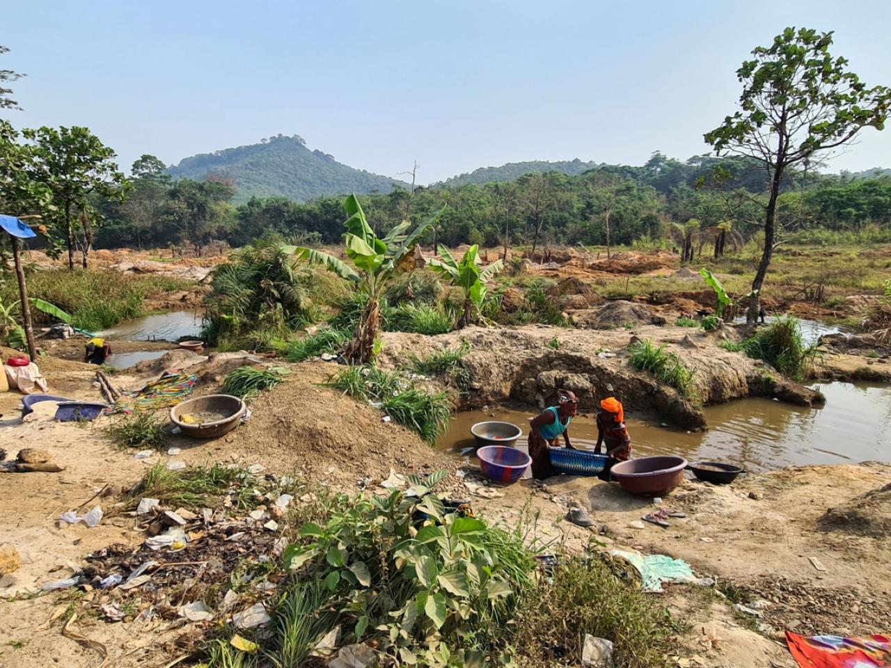 Two people pan for gold outside in Bolaneh, Sierra Leone