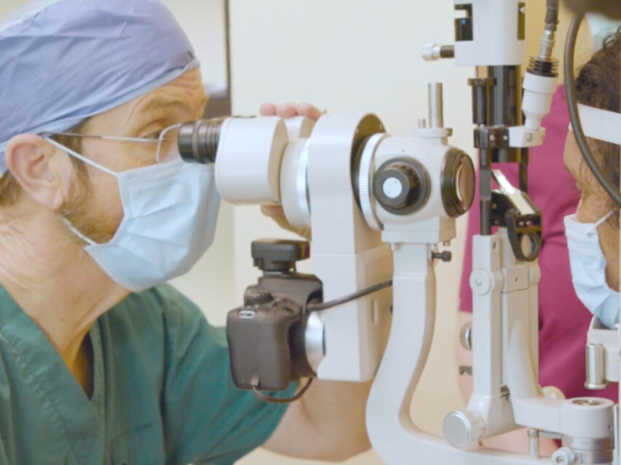 Opthalmologist looking through a microscope.