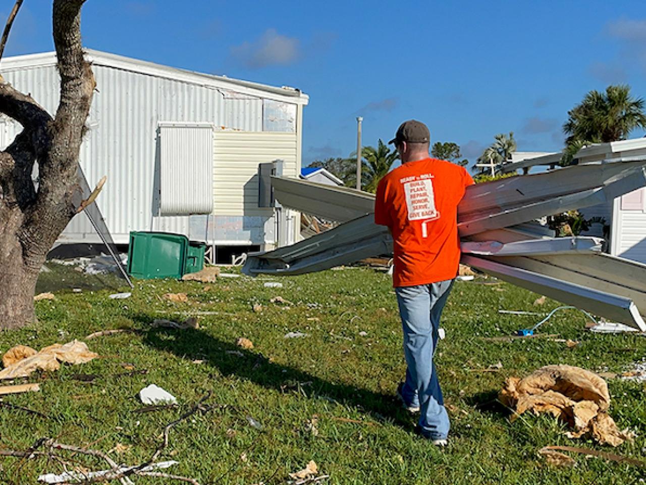 Home Depot volunteer shown cleaning up after Hurricane Ian.