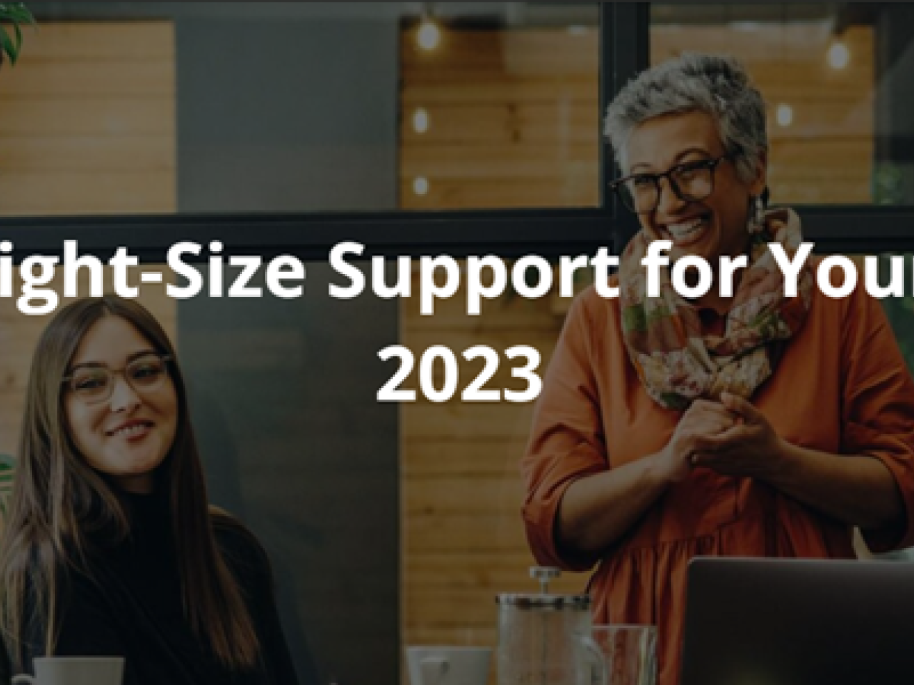 How to Right-Size Support for Your Team in 2023 Blog Image with a team of colleagues working around a desk discussing and smiling.