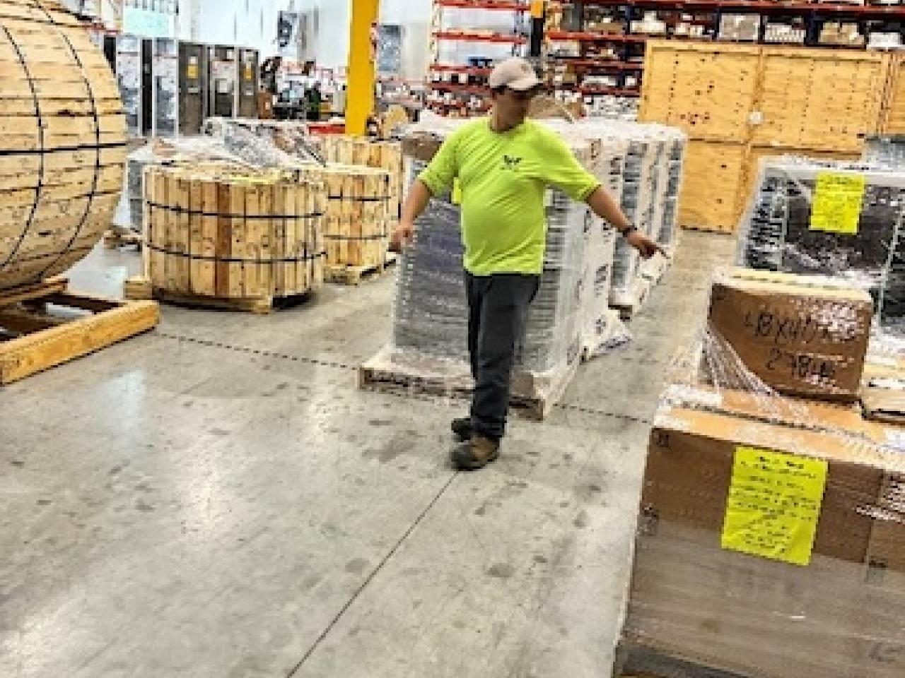 Worker in a Wesco warehouse preparing supplies for Hurricane Melissa relief.