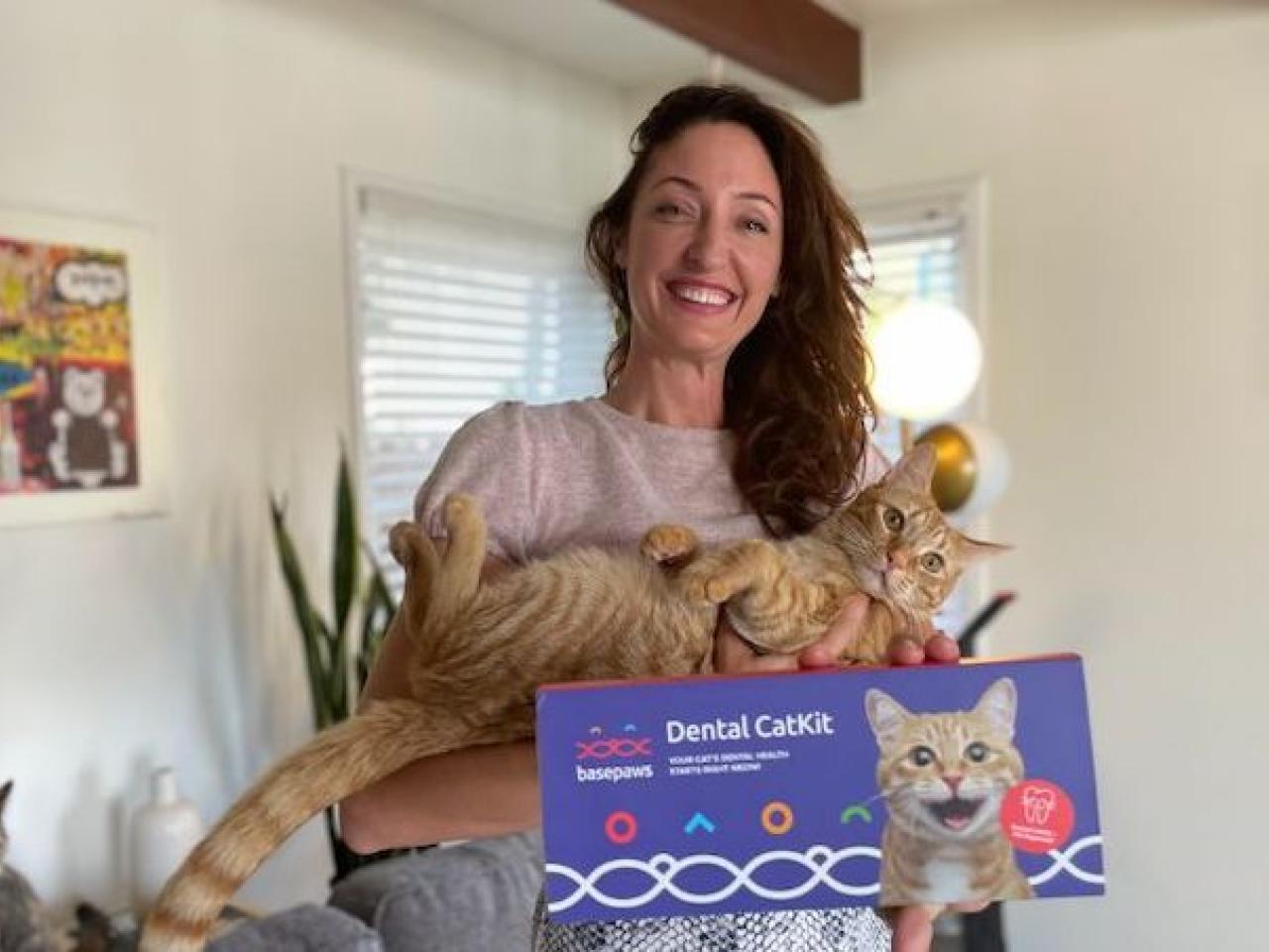 Anna Skaya holding her cat and a Dental CatKit