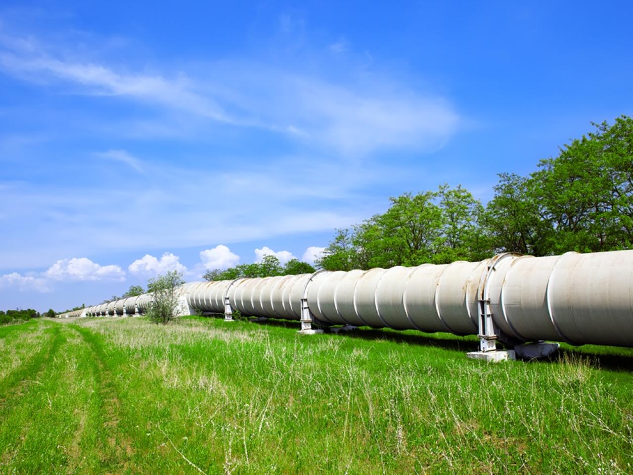 Pipeline in a grassy field with a blue sky