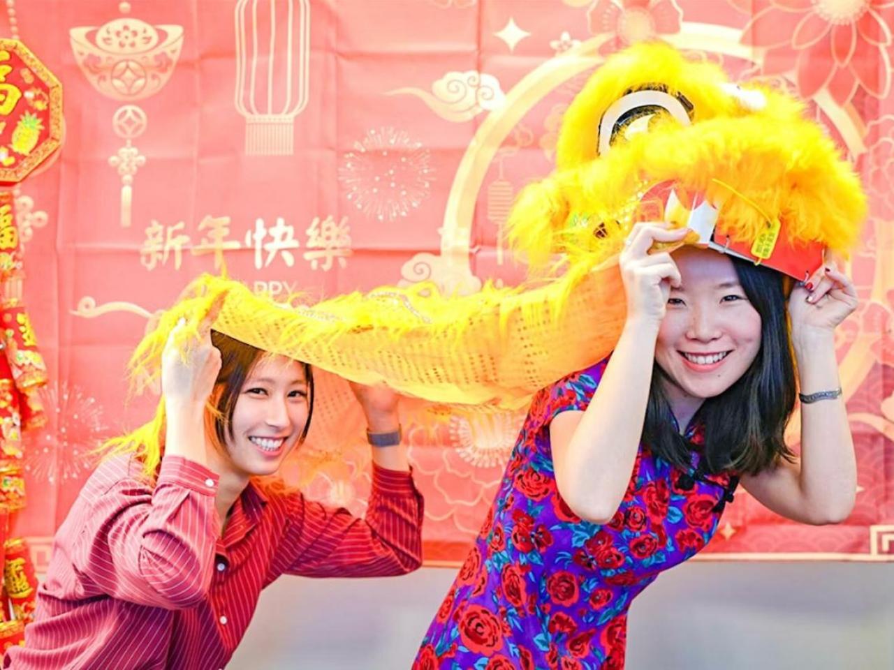 Two people holding a lion dance costume