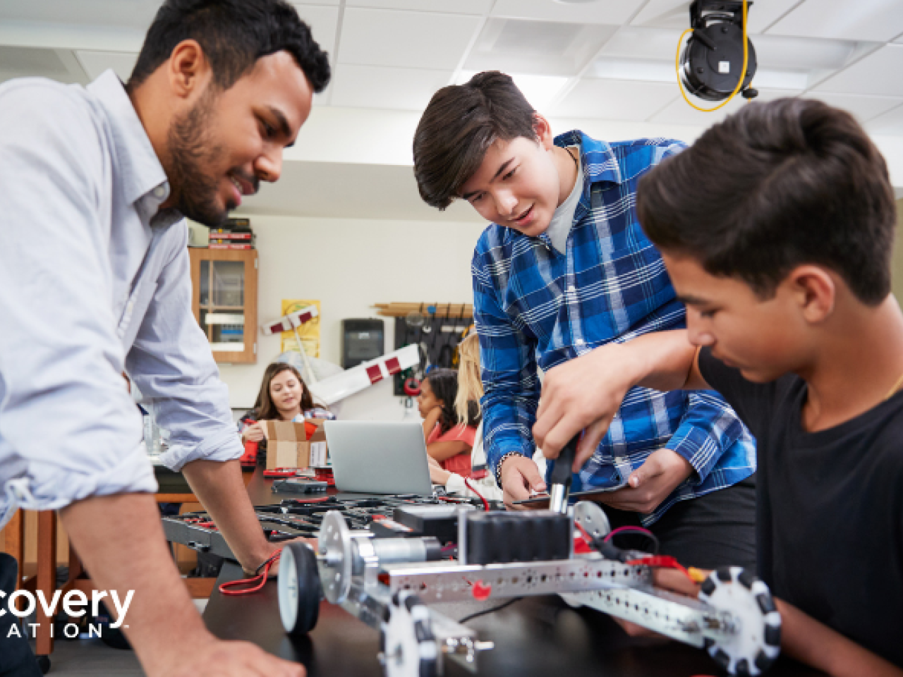 Student working with teacher on building a machine