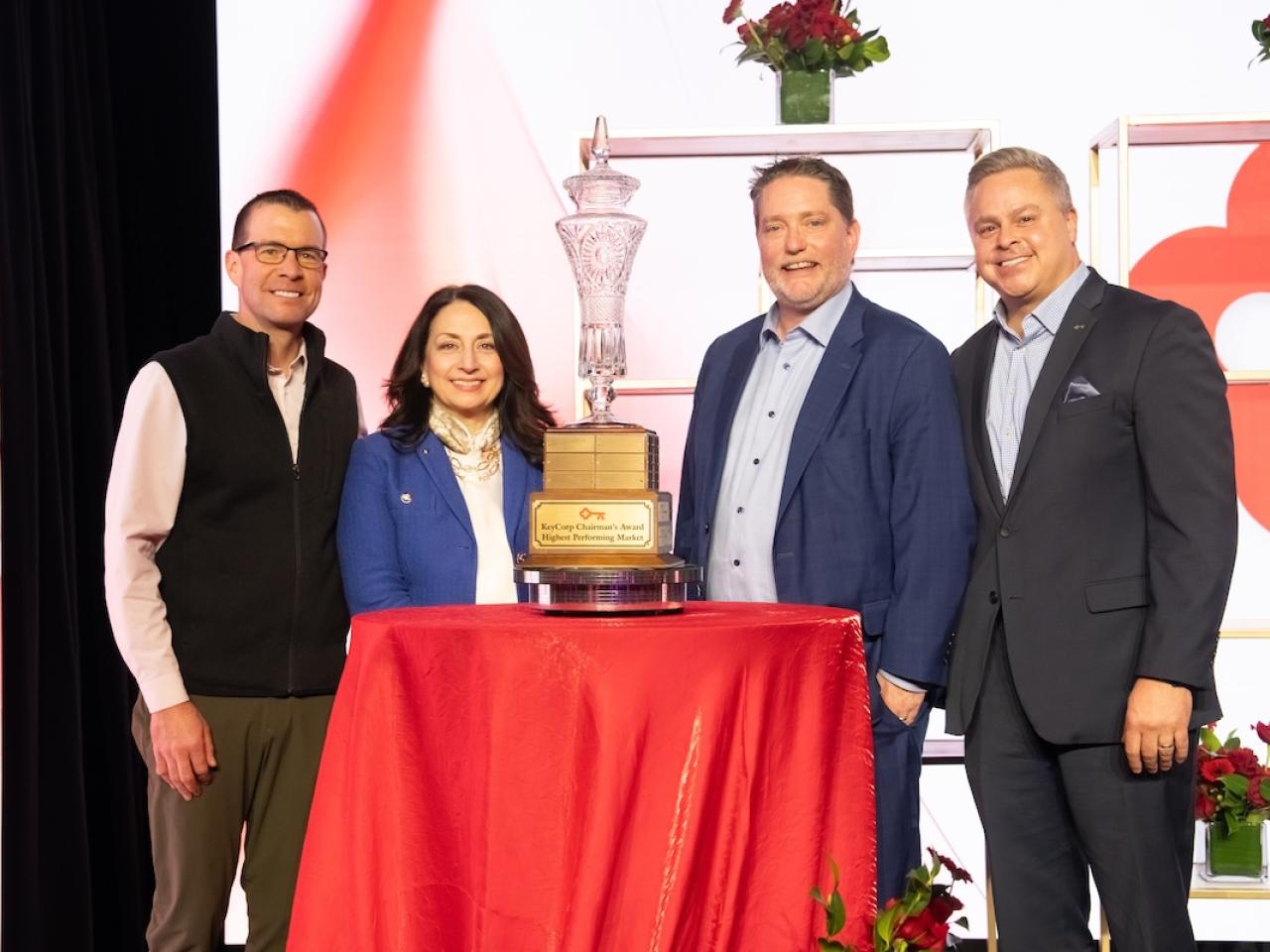 leaders standing around the trophy