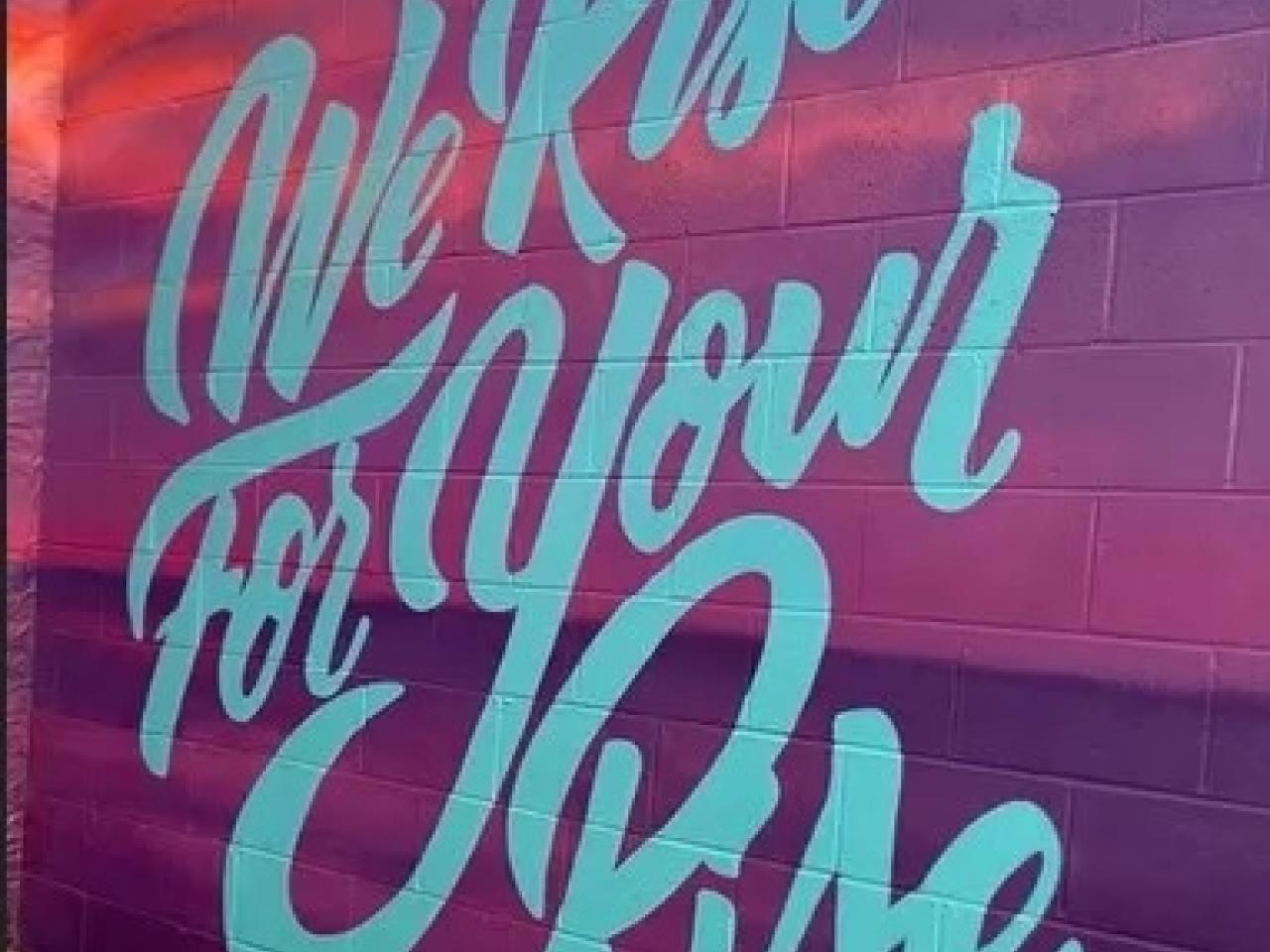 sign reading, "We Rise For Your Rise"