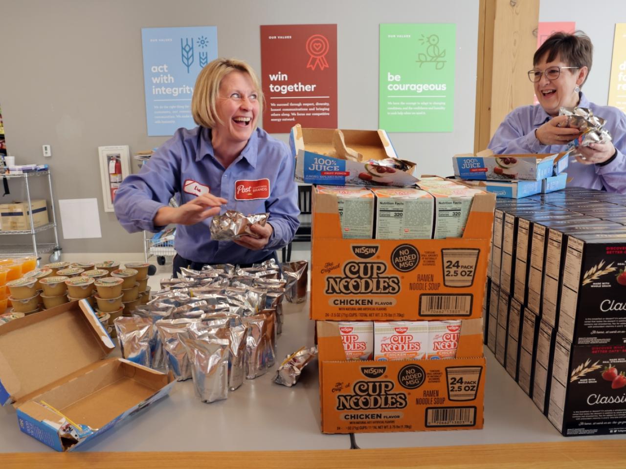 Employees of Post Consumer Brands pack bags of food