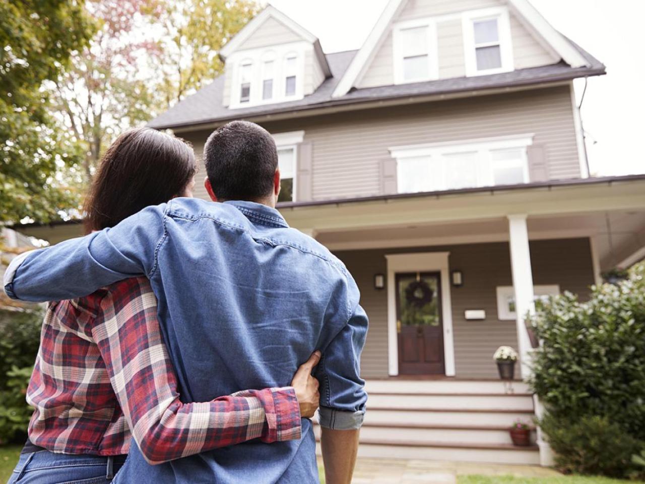 A couple embracing as they look at their new home.