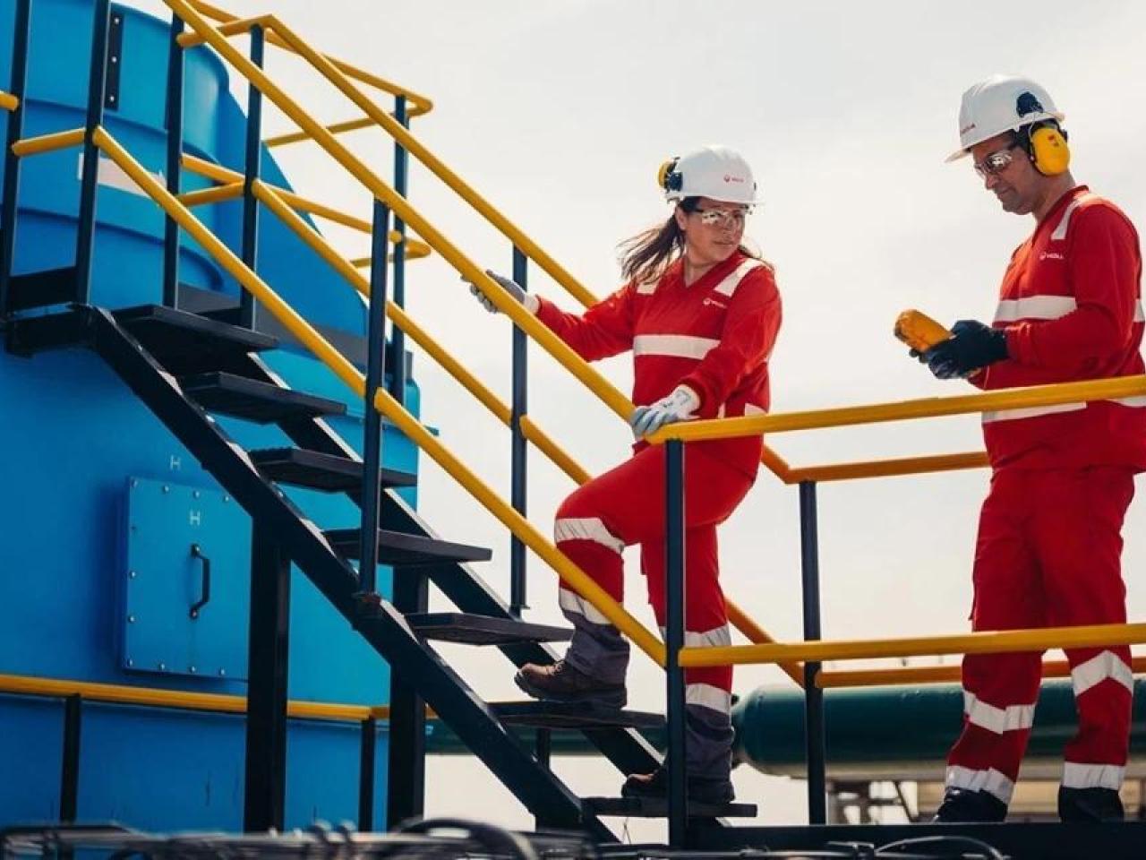 Two Veolia workers speaking to one another 