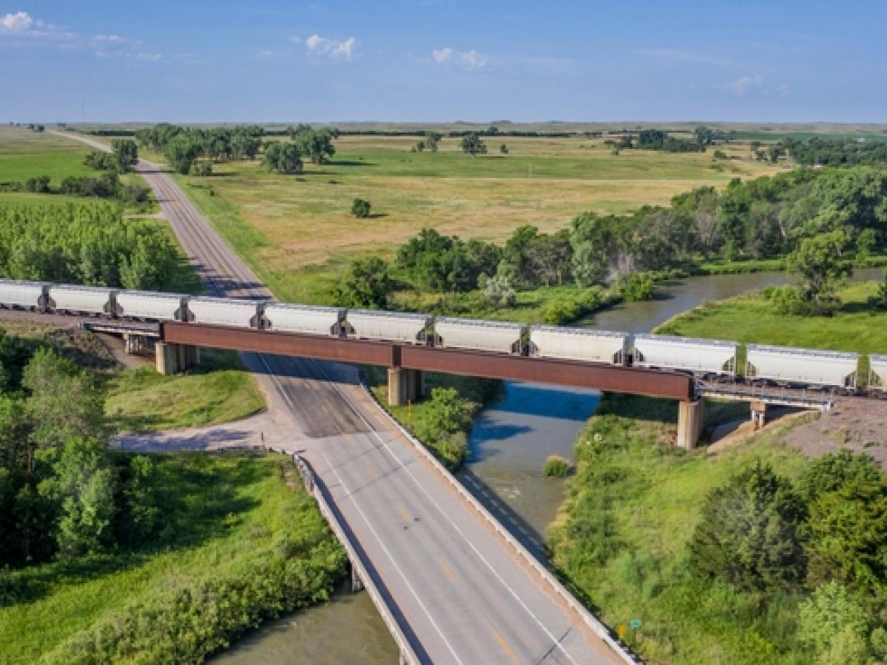 Train traveling on track through verdant landscape