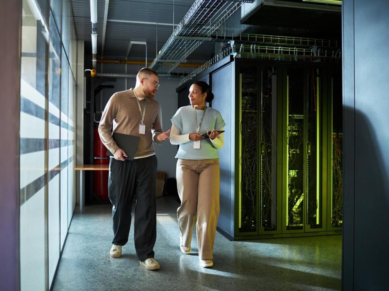 Two workers walking through a data center